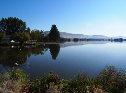 [Looking down the length of what seems to be a very long lake. There are mountains in the distance which seem to run for a long length and both they and the far end of the lake are in a haze.]